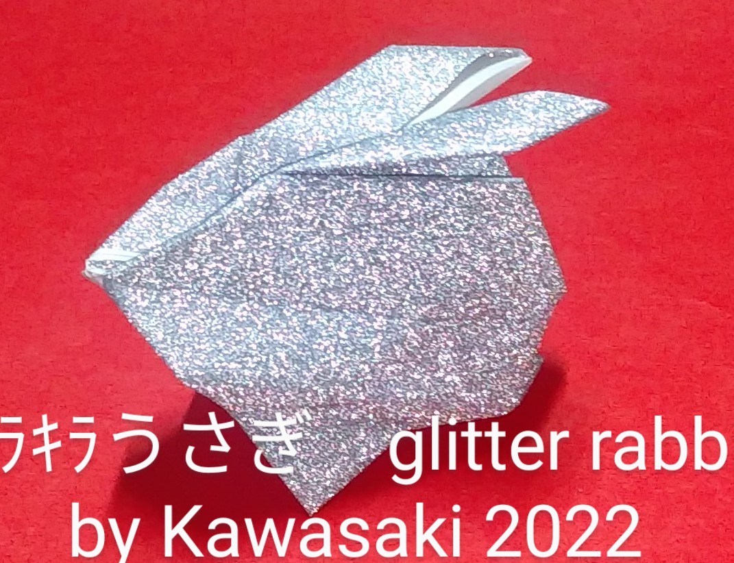 2022/11/20(Sun) 12:03「キラキラうさぎ　glitter rabbit（作2022年11月20日5時頃）  」川崎敏和T.Kawasaki
（創作者 Author：川崎敏和T.Kawasaki,　製作者 Folder：川崎敏和T.Kawasaki,　出典 Source：Kawasaki origami kit 2022）
 glit 1 sheet of 15cm square 【雪の子うさぎ】を用紙を変えて折りました。久留米の折り紙仲間がこのキラキラ紙で折ったものを真似しました。なお、白いもふもふの特殊紙は2018年に製造中止になって、現在は入手困難です。